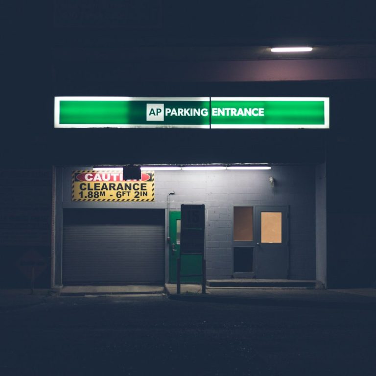 IT-Partner Beleuchtete Tankstelle mit abgedunkeltem Umfeld, Anzeigen in Neonfarbe.